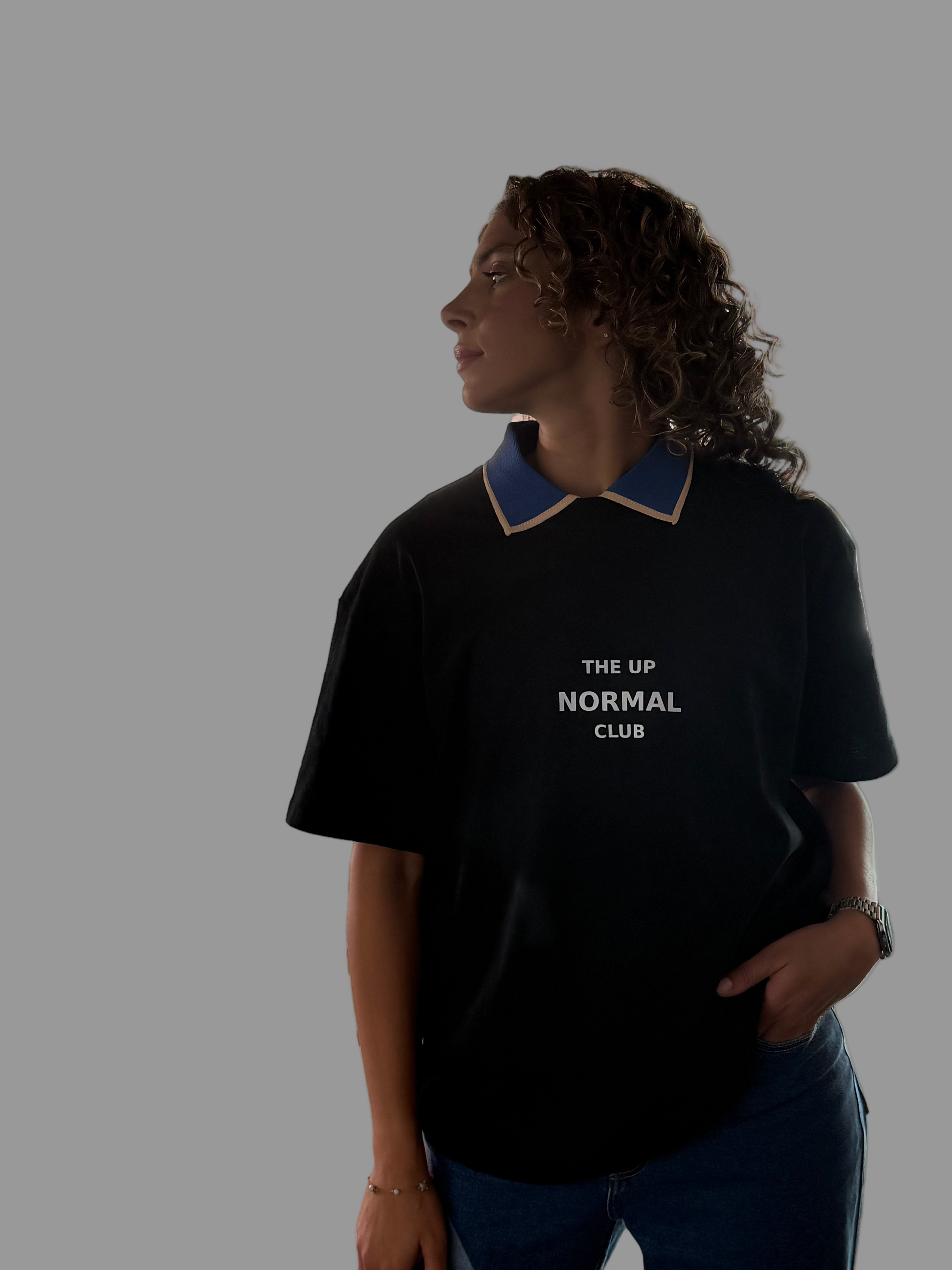 Person wearing a black t-shirt with 'The Up Normal Club' text on a gray background