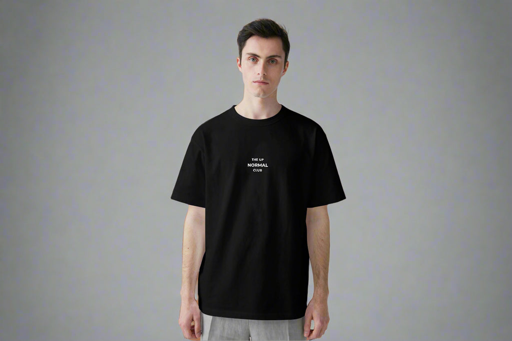 Man wearing a black t-shirt ,Round neck with logo  on a the chest 