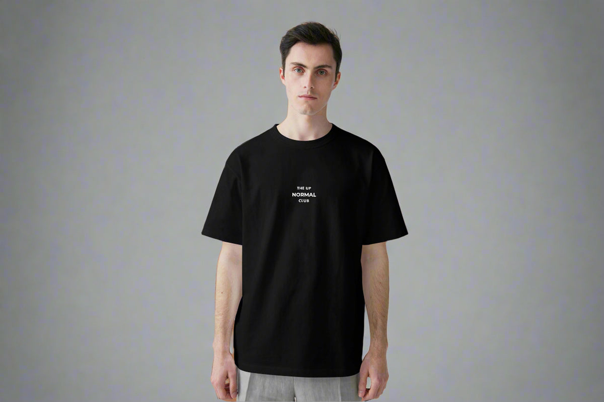 Man wearing a black t-shirt ,Round neck with logo  on a the chest 