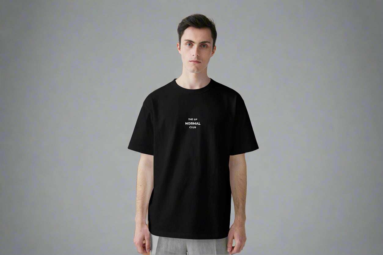 Man wearing a black t-shirt ,Round neck with logo  on a the chest 